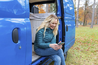 Midsection of woman using mobile phone while sitting in bus