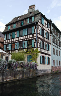 Building by canal against sky