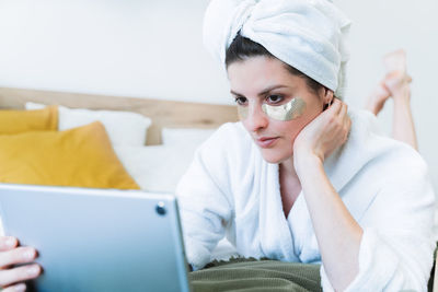 Portrait of woman relaxing on bed at home