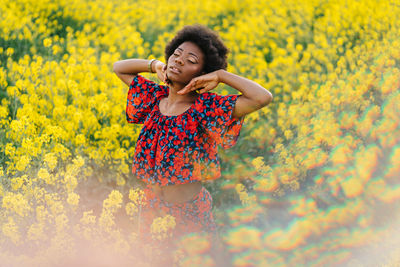 Young woman smiling in yellow flower field