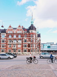 Bicycles on road by buildings against sky