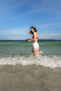 Full length of woman on beach against sky