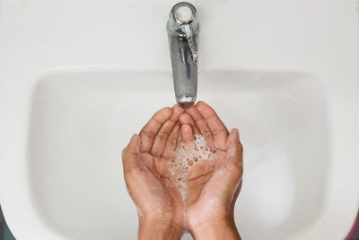 Cropped image of person washing hands