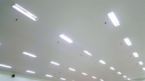 Low angle view of illuminated pendant lights hanging from ceiling