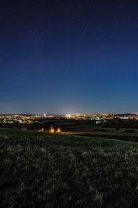 Scenic view of illuminated field against sky at night