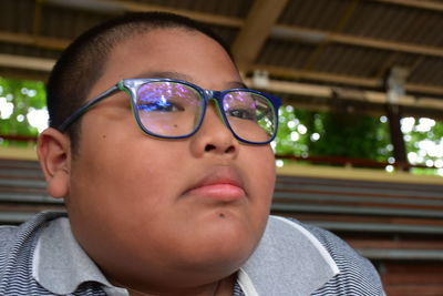 Close-up of boy wearing eyeglasses looking away