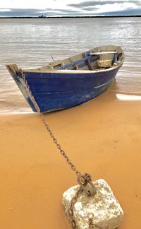 Close-up of boat moored at beach