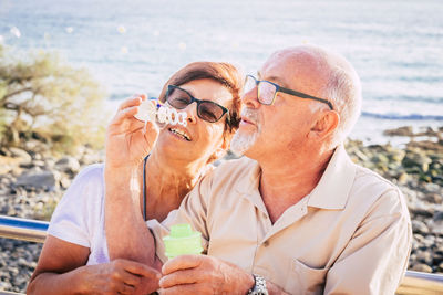 Midsection of couple kissing against sea