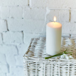 Close-up of lit candles on wall at home