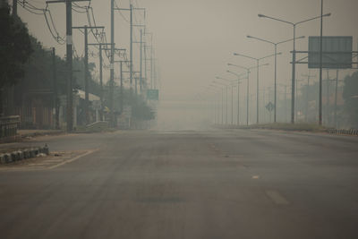 Surface level of empty road against sky in city