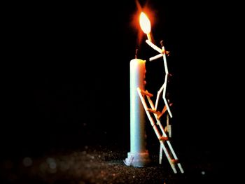 Close-up of burning candle in darkroom