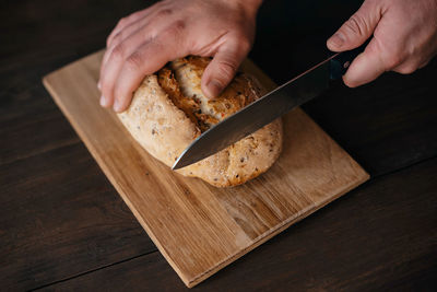 Cropped hand of person preparing food on cutting board