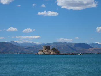 Bourtzi castle amidst sea and mountains against blue sky