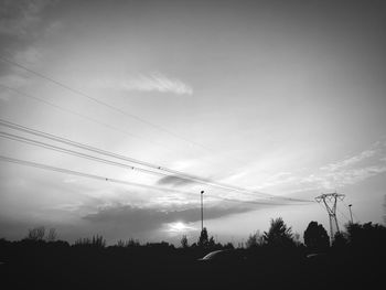 Silhouette of trees against cloudy sky