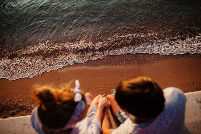 High angle view of couple sitting over sea