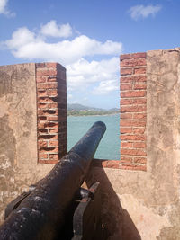 Close-up of stone wall by sea against sky