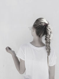 Rear view of woman with braided hair against white background