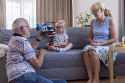 Side view of family sitting on sofa at home