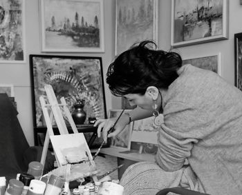 Side view of woman sitting on table at home