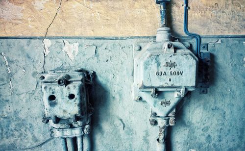 Close-up of old fuse boxes mounted on wall