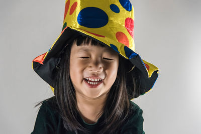 Close-up of smiling boy against white background