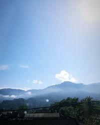 Scenic view of townscape and mountains against sky