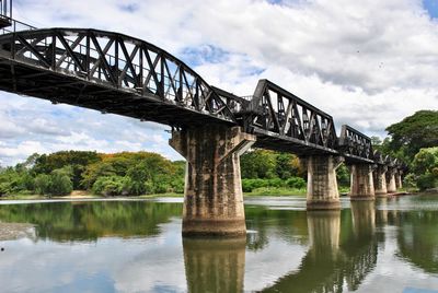 Low angle view of bridge over river against sky