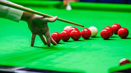 Close-up of hand playing pool on table