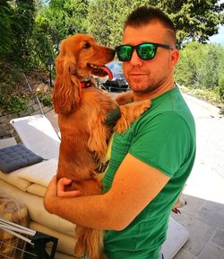 Portrait of man wearing sunglasses and dog