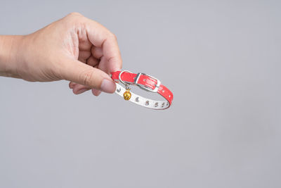 Close-up of hand holding hands over white background