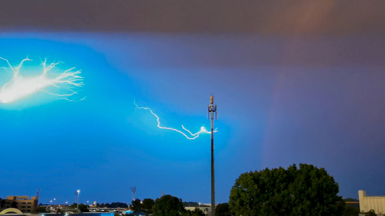 lightning, sky, power in nature, thunder, cloud, storm, nature, beauty in nature, thunderstorm, environment, architecture, night, electricity, no people, communication, city, sign, outdoors, illuminated, tree, building exterior, built structure