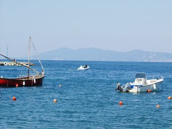 Sailboats in sea against sky