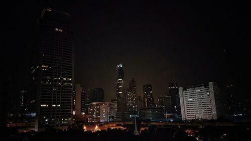 Low angle view of illuminated cityscape against sky at night