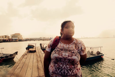Portrait of man standing in sea against sky
