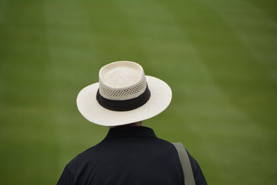 Rear view of man wearing straw hat on field