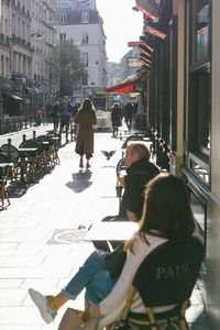 People walking on street amidst buildings in city