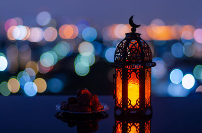 Lantern has moon symbol on top and small plate of dates fruit for holy month of ramadan kareem.