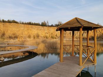 Wooden pier on lake against sky