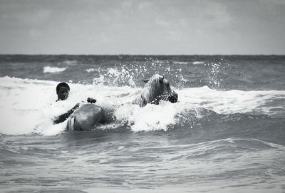 Waves splashing on sea against sky