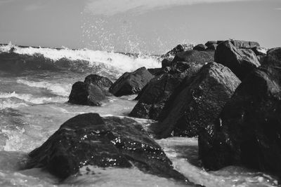 Rocks by sea against sky