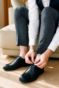 Low section of woman tying shoelace