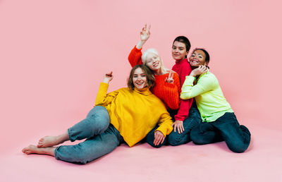 Portrait of lesbian women sitting on colored background