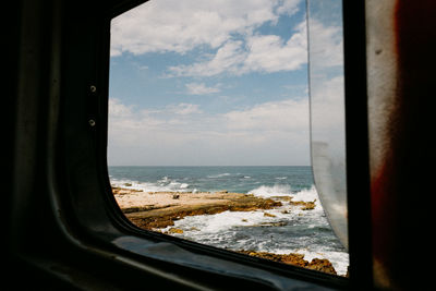 Scenic view of sea seen through glass window