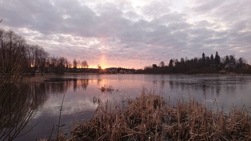 Scenic view of lake against sky at sunset