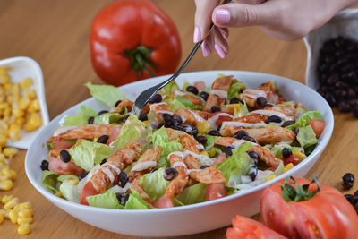 Close-up of hand holding salad in bowl