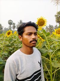 Portrait of young man against sunflower