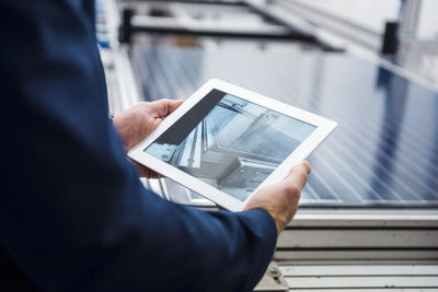 Businessman in solar factory holding tablet