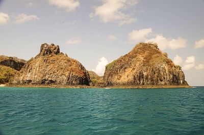 Panoramic view of rocks and sea against sky