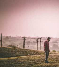 Man standing on field against clear sky