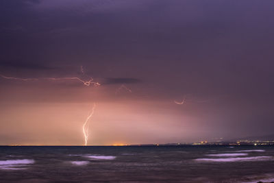 Lightning over sea against sky at night